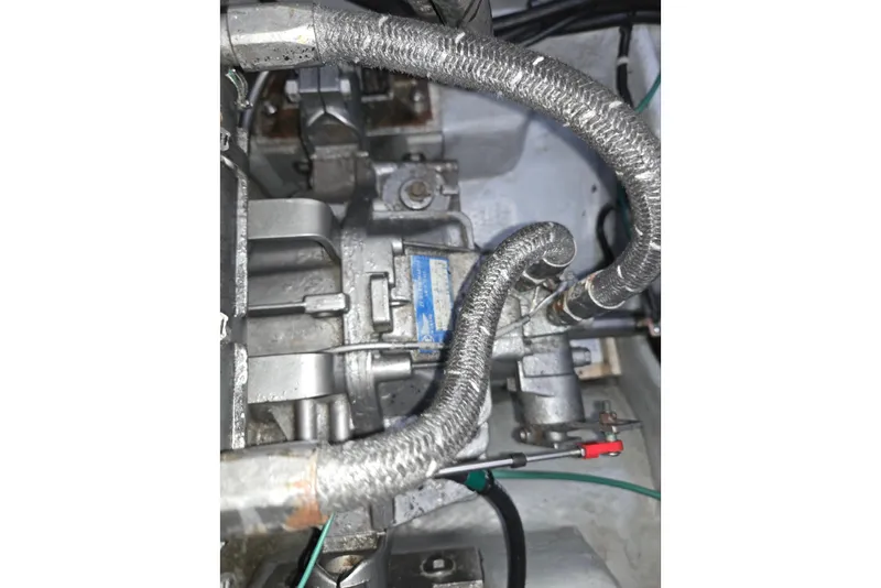Slide: The Image of Engine components of a 1998 Mainship Pilot 30 boat, featuring metal pipes and connectors. - 41