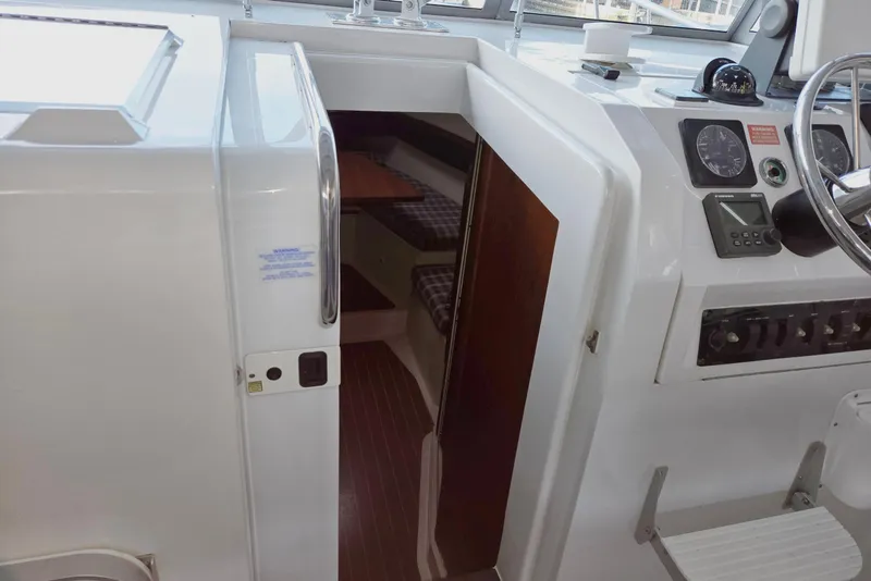 Slide: The Image of 1998 Mainship Pilot 30 cabin entrance and helm with steering wheel and controls. - 48