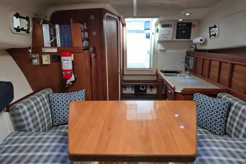 Slide: The Image of 1998 Mainship Pilot 30 interior with wood finishes, kitchenette, and seating area. - 49