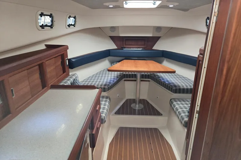 Slide: The Image of 1998 Mainship Pilot 30 cabin interior with wood finishes and plaid seating. - 50
