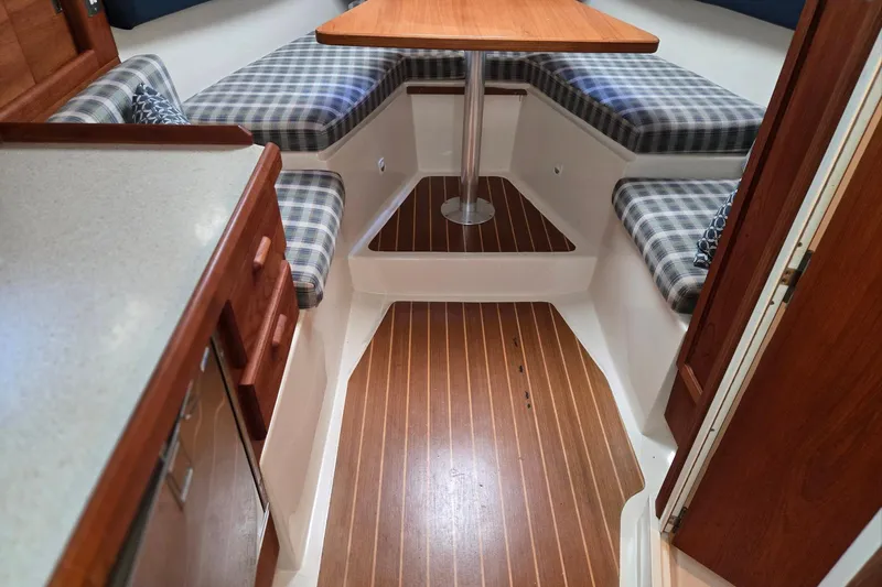 Slide: The Image of 1998 Mainship Pilot 30 cabin interior with wood flooring and plaid seating. - 51