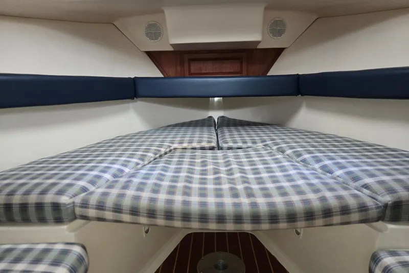 Slide: The Image of 1998 Mainship Pilot 30 cabin interior with plaid cushions and wood accents. - 56