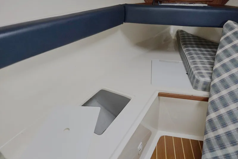 Slide: The Image of 1998 Mainship Pilot 30 cabin interior with plaid cushions and wooden flooring. - 57