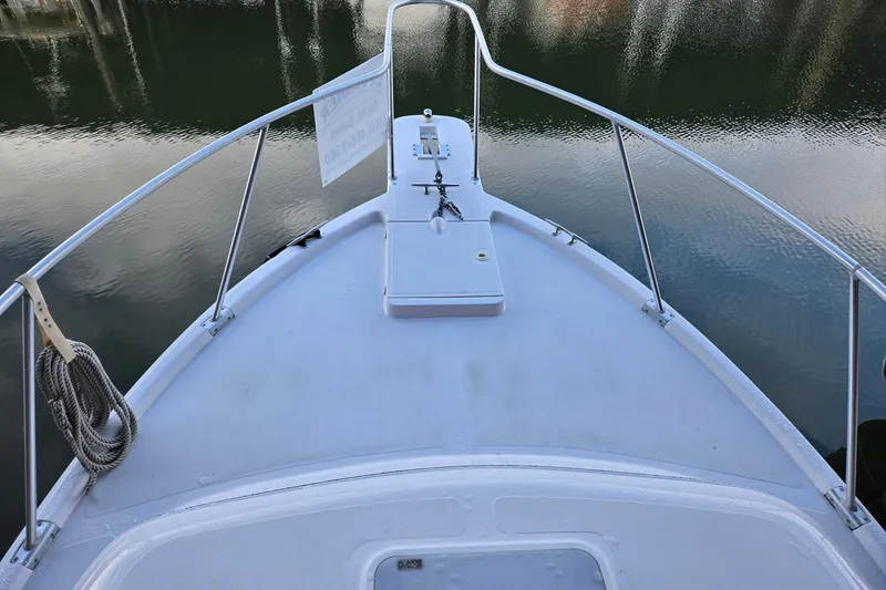 Slide: The Image of Bow view of 1998 Mainship Pilot 30 boat on calm water. - 6