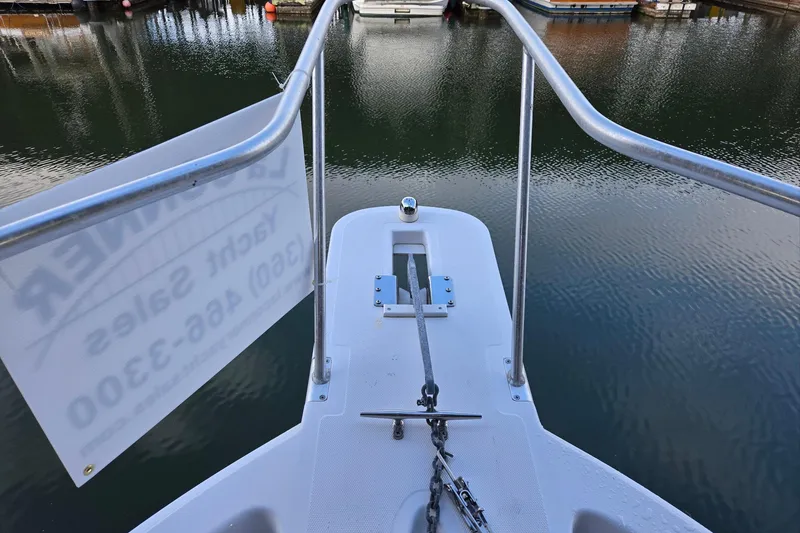 Slide: The Image of Bow view of 1998 Mainship Pilot 30 at marina, featuring anchor chain and railing. - 7