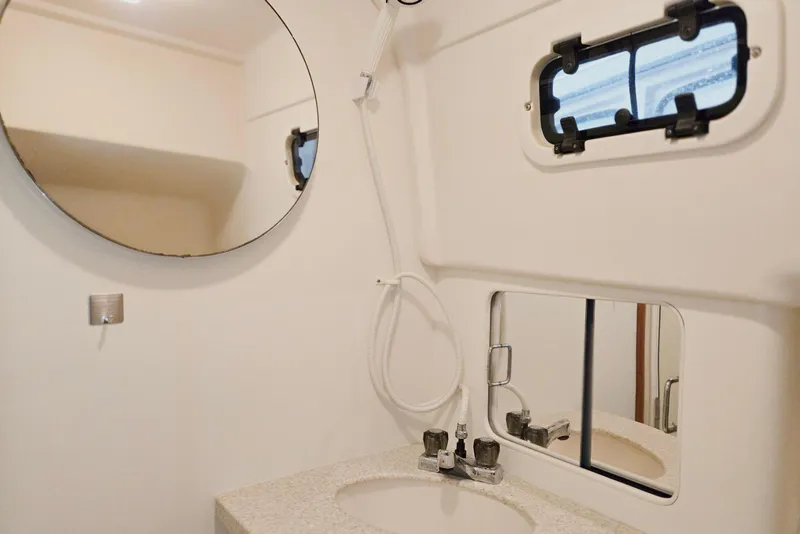 Slide: The Image of Bathroom interior of 1998 Mainship Pilot 30 boat with round mirror and porthole window. - 70