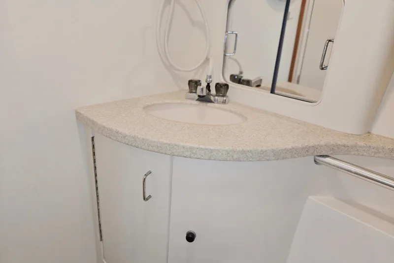 Slide: The Image of 1998 Mainship Pilot 30 bathroom with sink, mirror, and storage cabinet. - 72