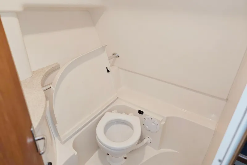 Slide: The Image of 1998 Mainship Pilot 30 boat bathroom with compact toilet and storage. - 73