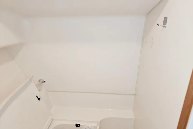 Slide: The Image of Interior of 1998 Mainship Pilot 30 boat, featuring a compact, white bathroom space. - 74