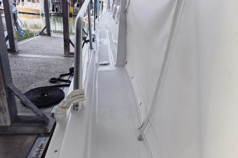 Slide: The Image of 1998 Mainship Pilot 30 docked, showing side deck and railing details. - 9