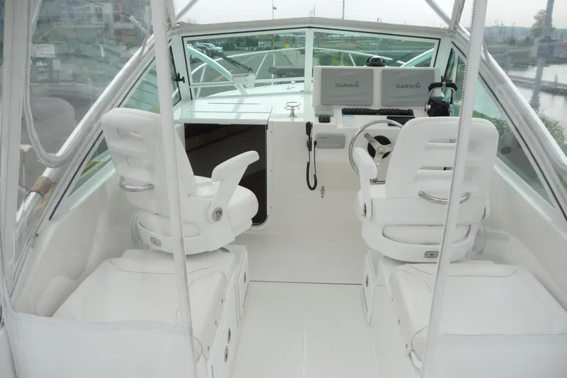 Slide: The Image of 2016 Albemarle 25 Express boat cockpit with white seating and Garmin navigation system. - 24