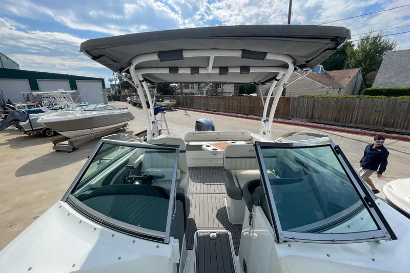 Slide: The Image of 2018 Cobalt 25SC boat with canopy, docked outdoors under a partly cloudy sky. - 16