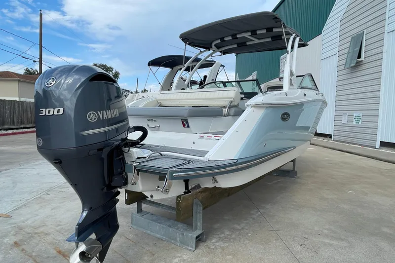 Slide: The Image of 2018 Cobalt 25SC boat with Yamaha 300 outboard engine, docked outdoors. - 2