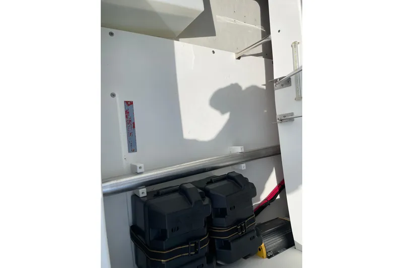 Slide: The Image of Interior view of a 2018 Cobalt 25SC boat storage compartment with battery boxes. - 21