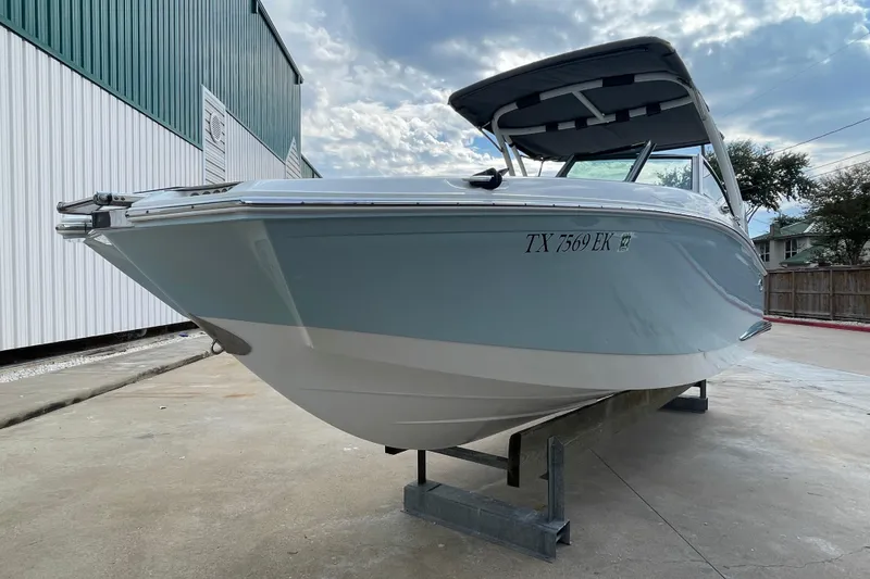 Slide: The Image of 2018 Cobalt 25SC boat on display, light blue hull, parked outdoors. - 5