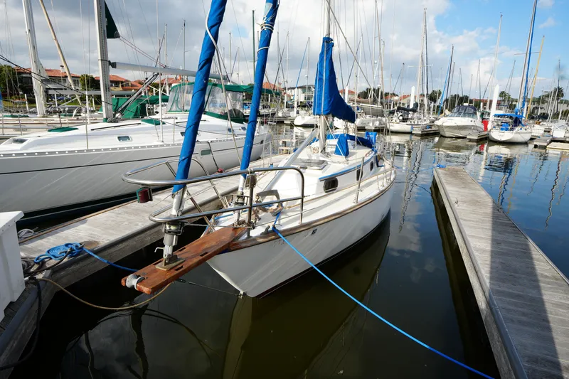 The Image of 1983 Cape Dory 30c sailboat docked in a marina with other boats. - 0