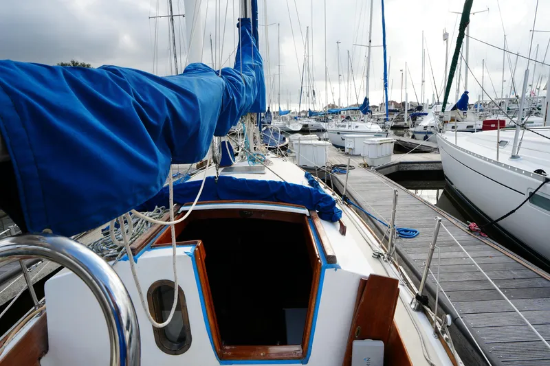 Slide: The Image of 1983 Cape Dory 30c sailboat docked at marina, featuring blue sail cover. - 12