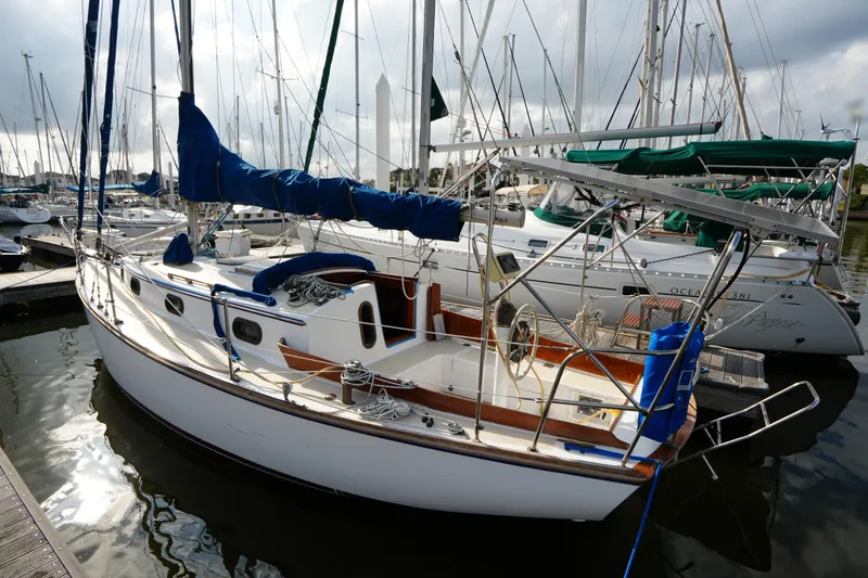 Slide: The Image of 1983 Cape Dory 30c sailboat docked in a marina, surrounded by other boats. - 15