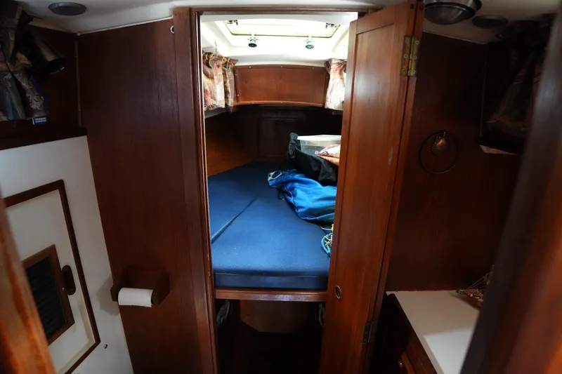 Slide: The Image of Interior cabin of 1983 Cape Dory 30c sailboat with blue bedding and wooden finish. - 18