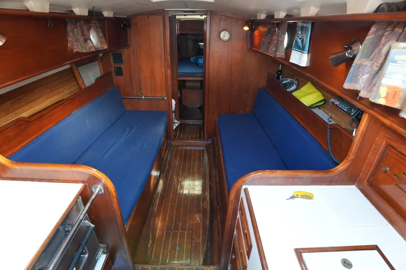 Slide: The Image of 1983 Cape Dory 30c sailboat interior with blue seating and wooden finishes. - 25