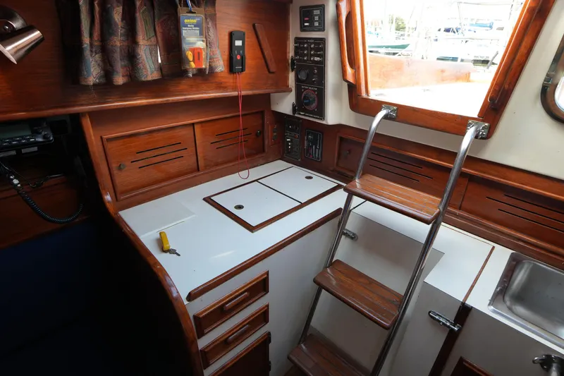 Slide: The Image of 1983 Cape Dory 30c sailboat interior with wooden cabinetry and ladder. - 29