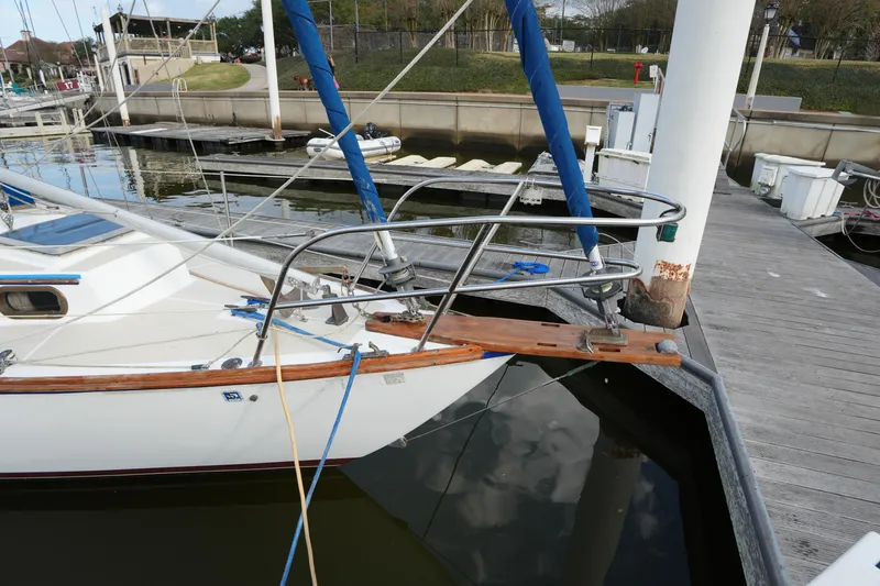 Slide: The Image of 1983 Cape Dory 30c sailboat docked, featuring a wooden bowsprit and blue rigging. - 4