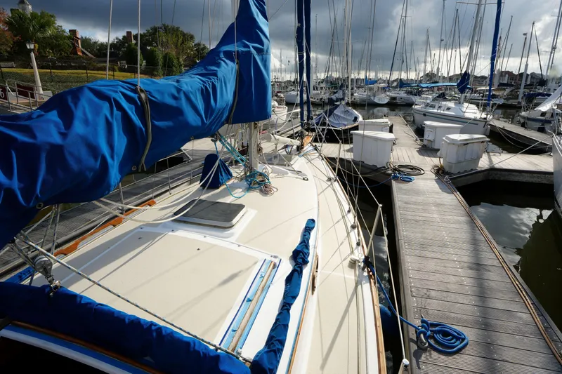 Slide: The Image of 1983 Cape Dory 30c sailboat docked at marina under cloudy sky. - 5