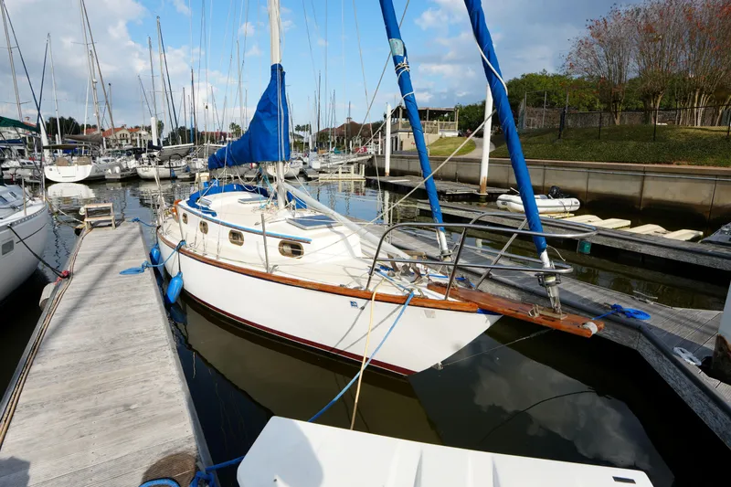 Slide: The Image of 1983 Cape Dory 30c sailboat docked in a marina, surrounded by other boats. - 7