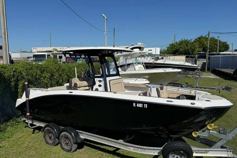 Slide: The Image of 2023 Yamaha Boats 255 FSH Sport E on trailer, parked outdoors. - 2