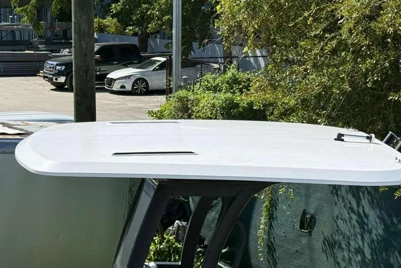 Slide: The Image of 2023 Yamaha Boats 255 FSH Sport E T-top in a parking area. - 21