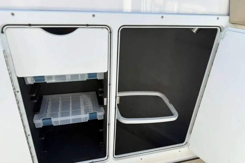 Slide: The Image of Storage compartments on 2023 Yamaha Boats 255 FSH Sport E, featuring organized shelving. - 22