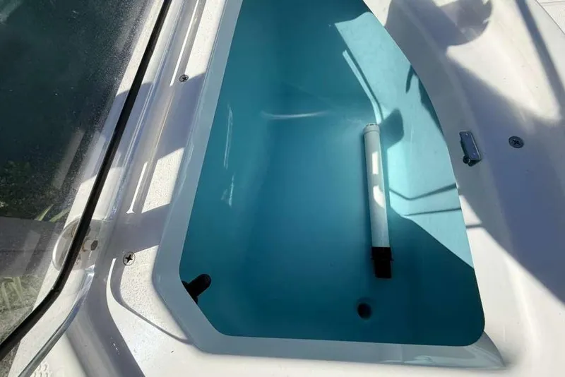 Slide: The Image of 2023 Yamaha Boats 255 FSH Sport E livewell interior with blue water. - 24