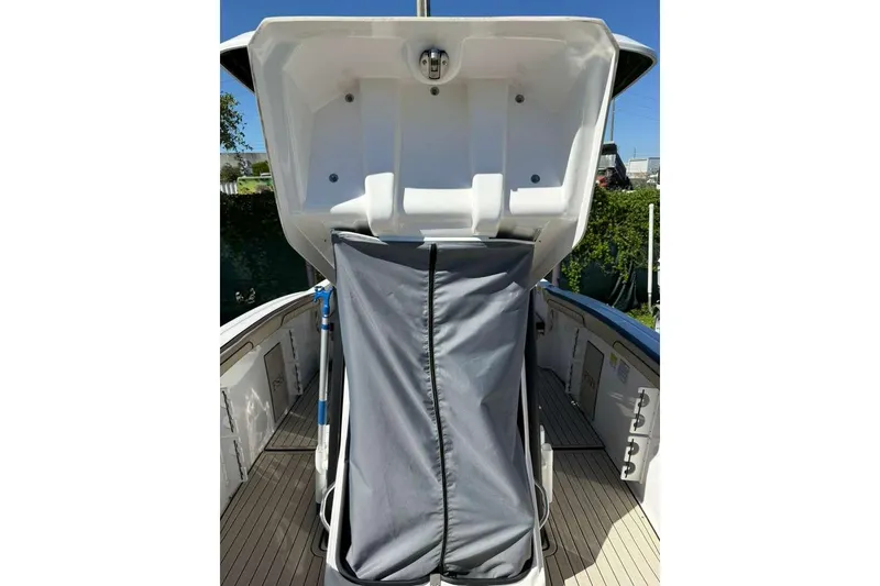Slide: The Image of 2023 Yamaha Boats 255 FSH Sport E, open storage compartment, sleek design, outdoor setting. - 34