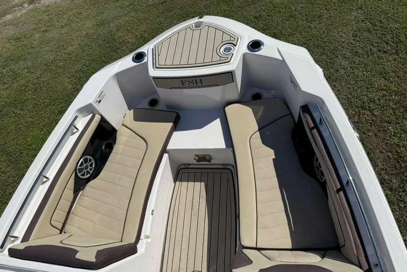 Slide: The Image of 2023 Yamaha Boats 255 FSH Sport E interior with beige seating and deck, viewed from above. - 6