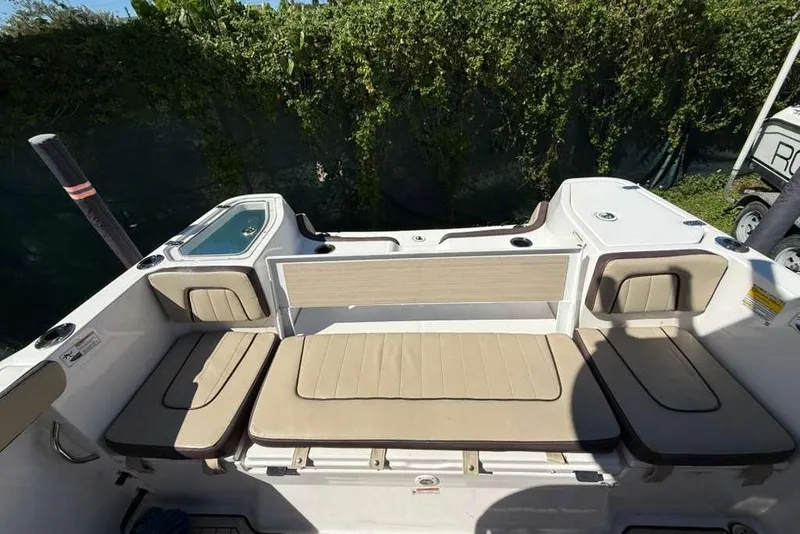 Slide: The Image of 2023 Yamaha Boats 255 FSH Sport E interior seating with beige cushions. - 7