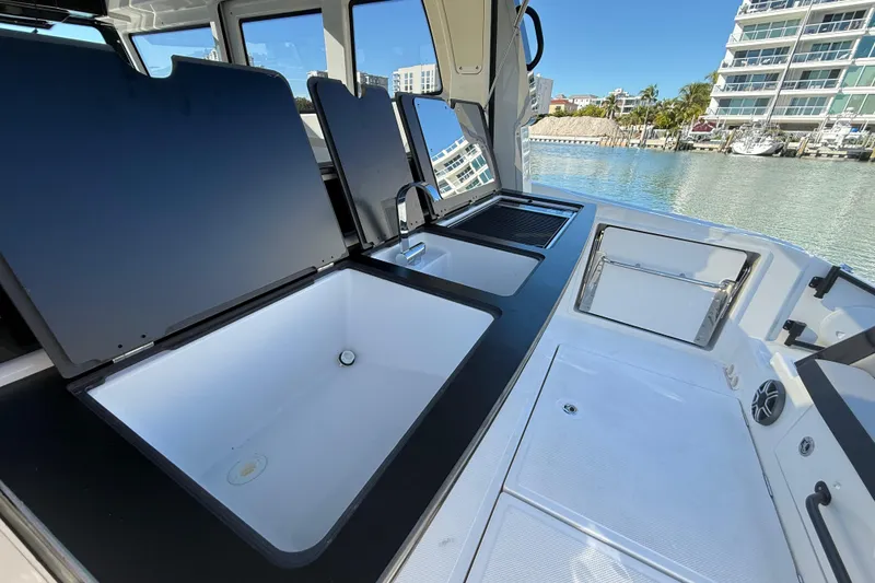 Slide: The Image of 2026 Navan C30 boat interior with open storage compartments and sink, docked by waterfront buildings. - 17