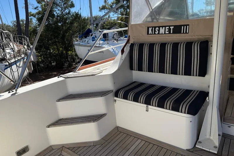 Slide: The Image of 1999 Sabre 36 Express boat interior with striped seating and wooden steps. - 11