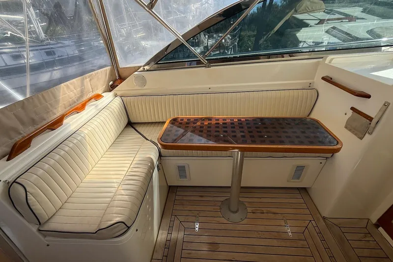 Slide: The Image of 1999 Sabre 36 Express yacht interior with cushioned seating and wooden table. - 15
