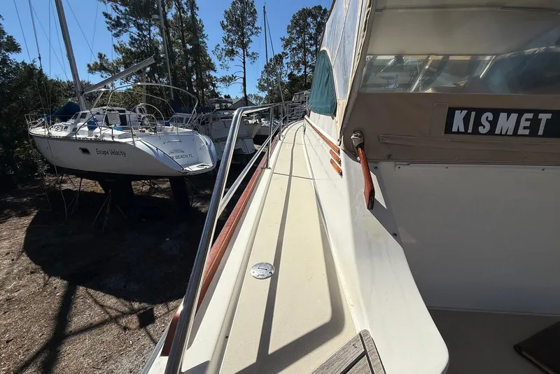 Slide: The Image of 1999 Sabre 36 Express yacht "Kismet" docked beside sailboats in a wooded area. - 19