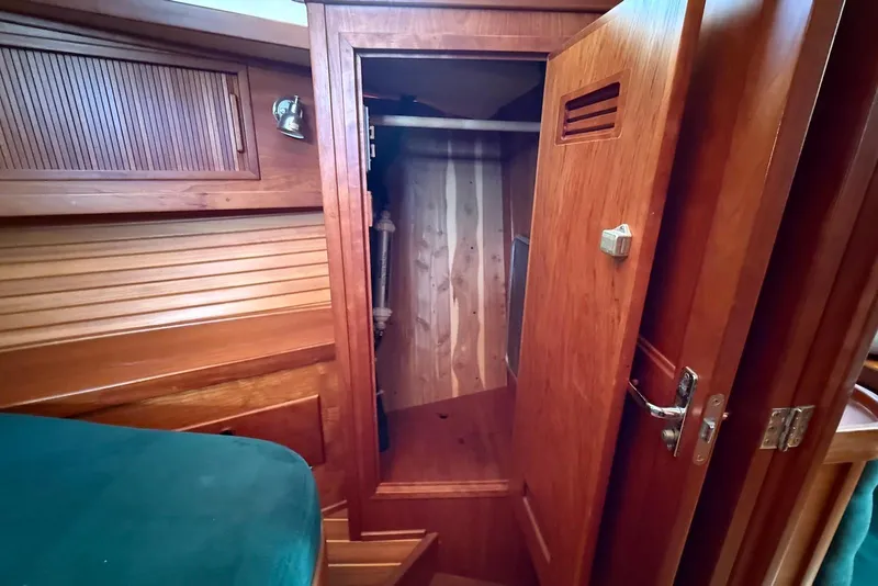 Slide: The Image of Wooden interior of 1999 Sabre 36 Express yacht, featuring an open closet and storage area. - 26