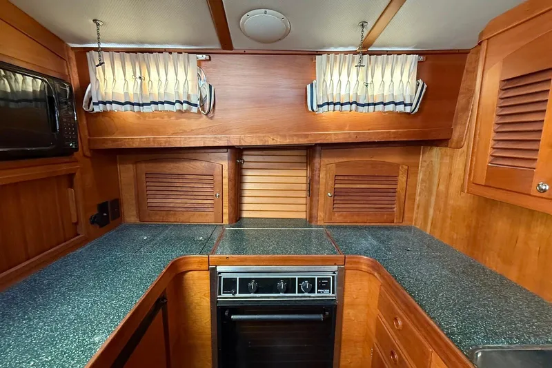 Slide: The Image of 1999 Sabre 36 Express yacht kitchen with wood cabinetry and modern appliances. - 29