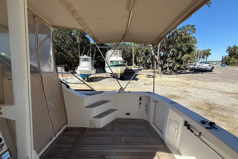 Slide: The Image of 1999 Sabre 36 Express boat deck with canopy, docked near other boats. - 3