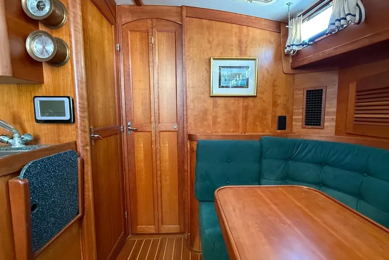 Slide: The Image of 1999 Sabre 36 Express yacht interior with wood finish and green seating. - 31