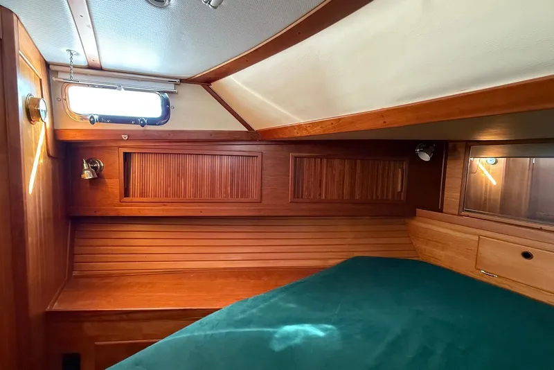 Slide: The Image of Cozy cabin interior of 1999 Sabre 36 Express yacht with wooden paneling and green bedding. - 33