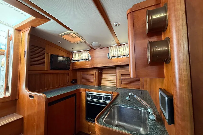 Slide: The Image of 1999 Sabre 36 Express yacht interior kitchen with wood cabinetry and modern appliances. - 34