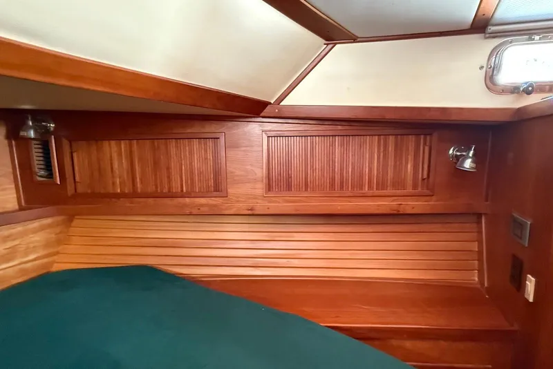 Slide: The Image of 1999 Sabre 36 Express cabin interior with wooden paneling and green bedding. - 35