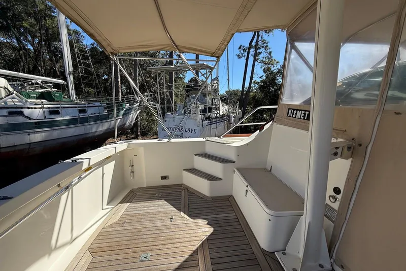 Slide: The Image of 1999 Sabre 36 Express boat deck with wooden flooring and canopy. - 4
