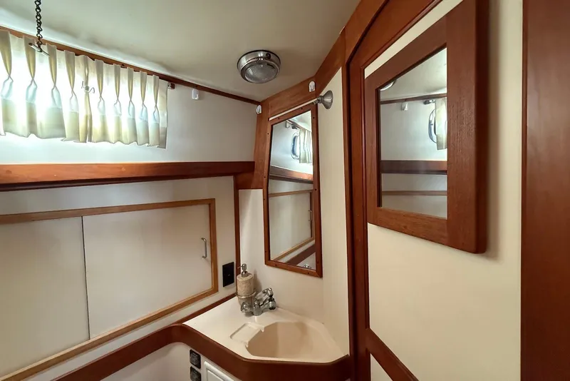Slide: The Image of 1999 Sabre 36 Express yacht bathroom with wood accents and mirror. - 41