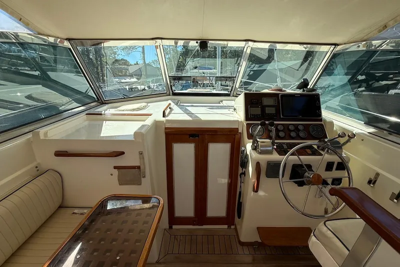 Slide: The Image of 1999 Sabre 36 Express boat cockpit with steering wheel, navigation instruments, and seating area. - 6