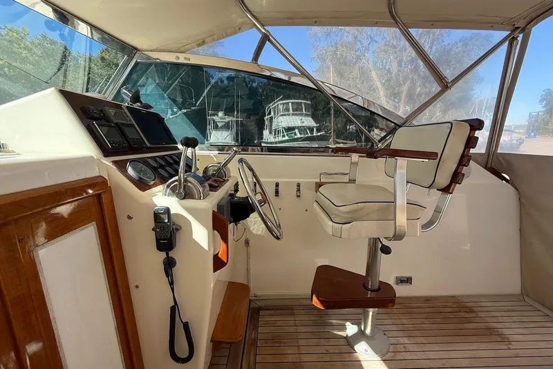 Slide: The Image of 1999 Sabre 36 Express helm with captain's chair, steering wheel, and navigation instruments. - 7
